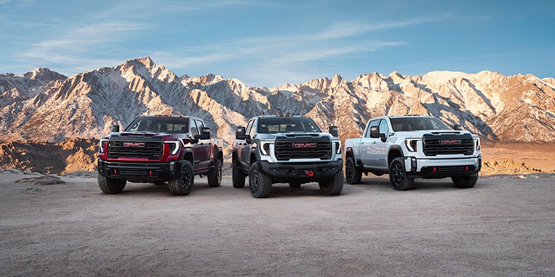2024 GMC Sierra HD with other trucks parked in desert